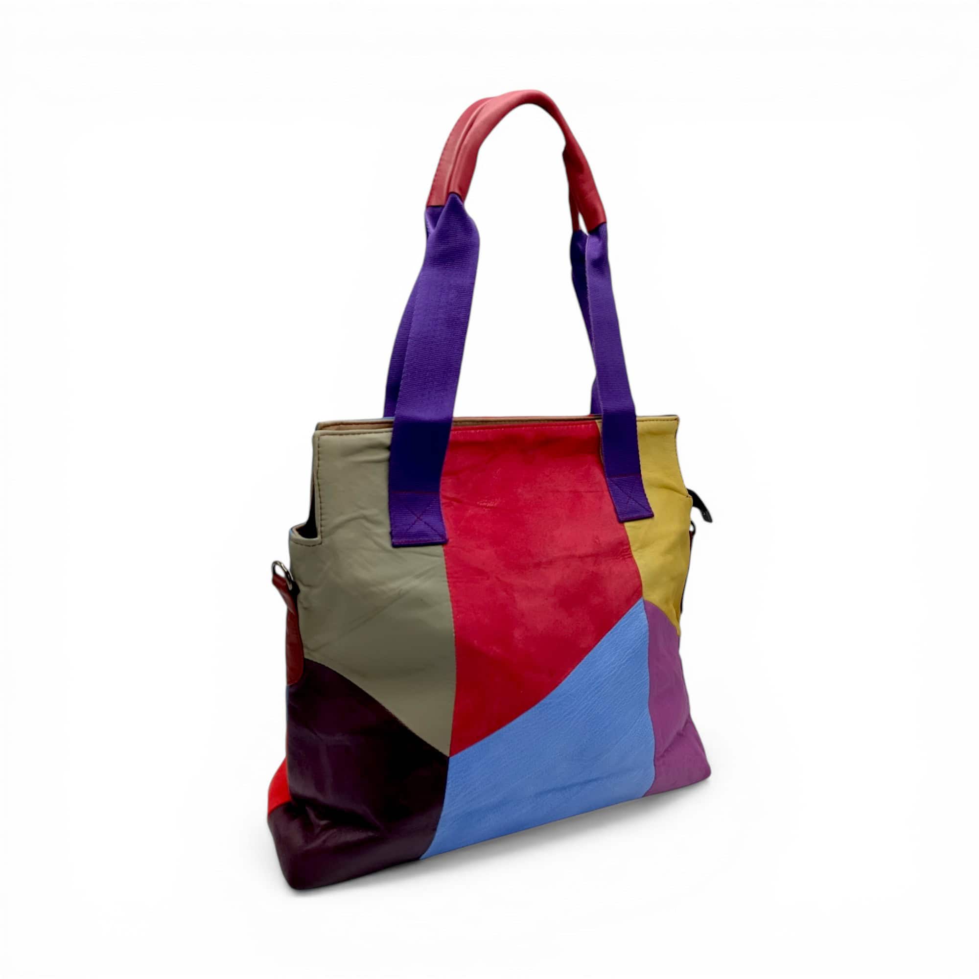 Geantă de umăr vibrantă cu design geometric și mânere colorate.