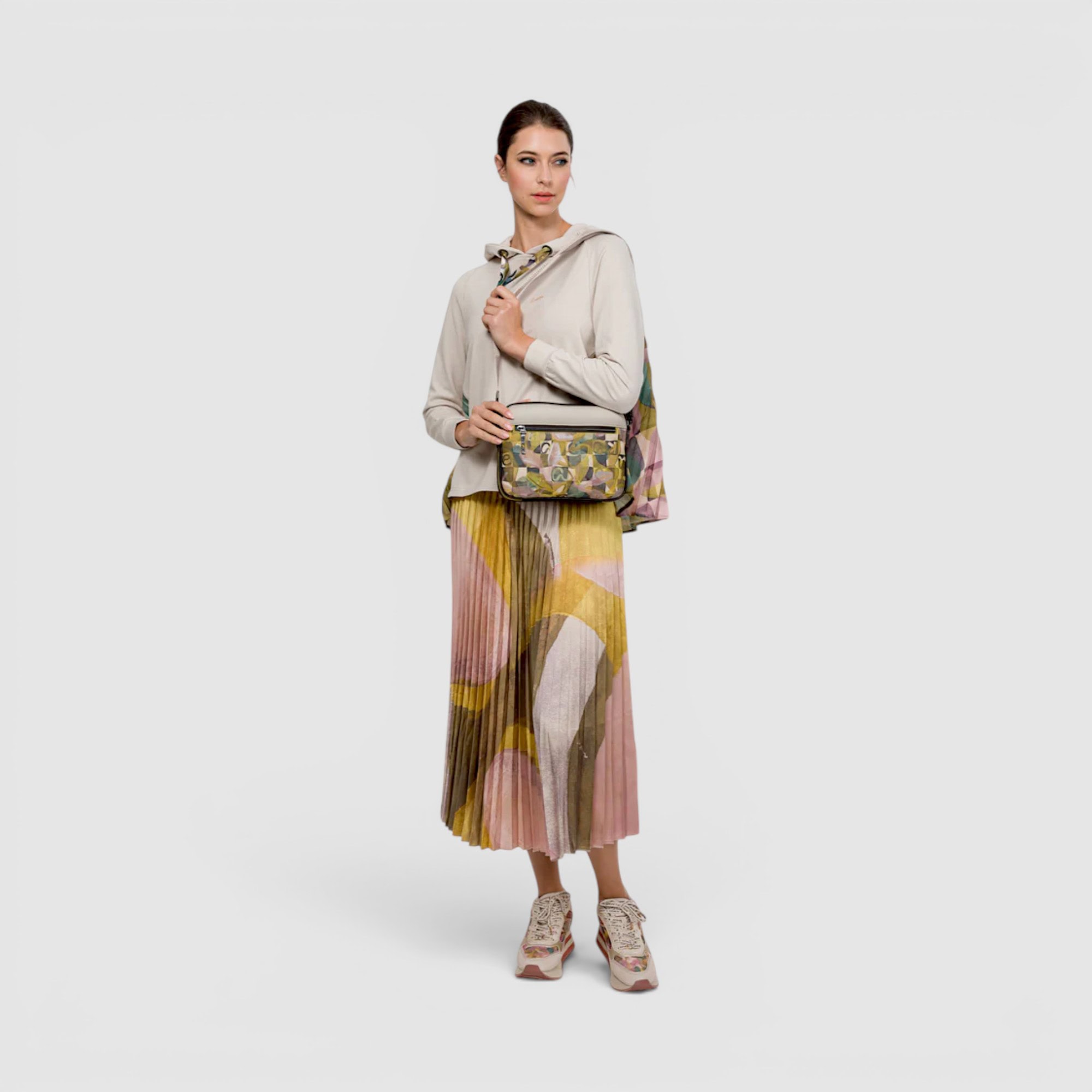 Femeie în ținută casual cu fustă colorată și geantă, stil modern și confortabil.