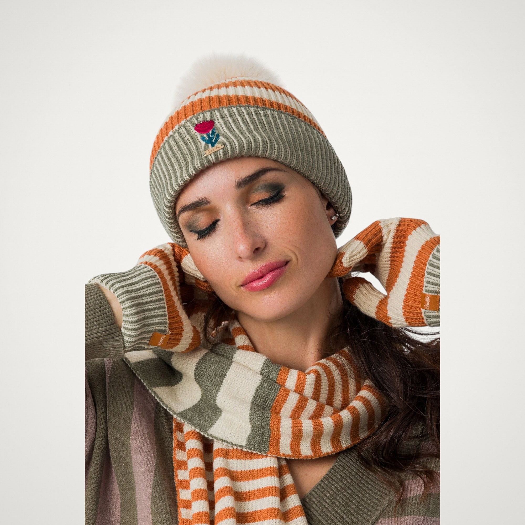 Căciulă damă Anekke Tulip 43471-321 – tricotată, în dungi, cu pompon Căciulă damă Anekke Tulip 43471-321 – purtată, cu fular și mănuși din aceeași colecție